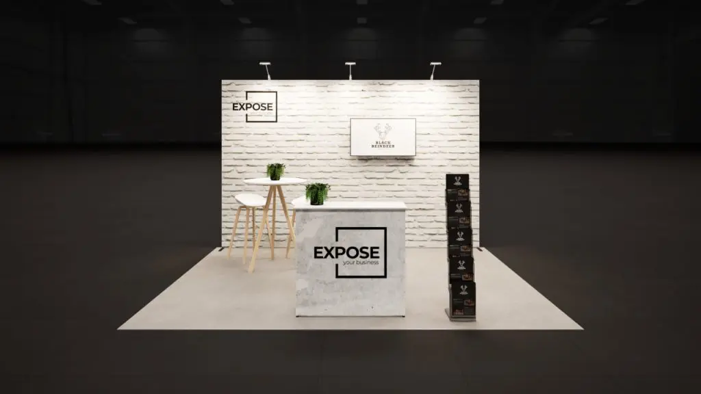 Beursstand met witte bakstenen beurswand, balie, folderrek en hoge tafel met barkrukken voor een professionele presentatie op de beurs.